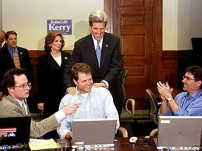 Democratic presidential candidate Senator John Kerry congratulates staff members as news reports say rival Senator John Edwards is dropping out of the race.