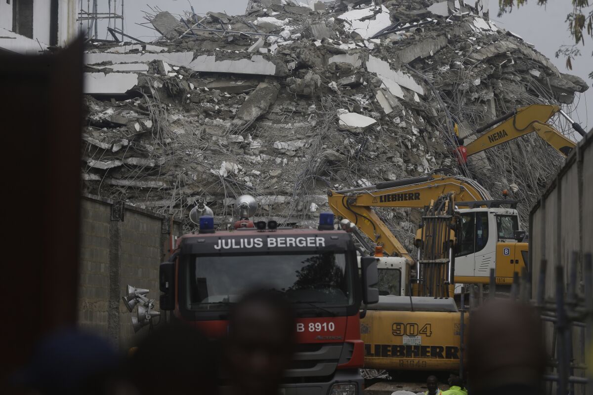 A view of the rubble of the collapsed 21-story apartment building under construction in Lagos, Nigeria, Tuesday, Nov. 2, 2021. Authorities in Nigeria's largest city say the owner of a high-rise apartment building that collapsed suddenly has been arrested. The news came Tuesday as officials announced that 14 people had been confirmed dead following Monday's accident. Dozens of others are believed to still be trapped in the rubble of the 21-story building that was under construction in the Ikoyi area of Lagos. (AP Photo/Sunday Alamba)