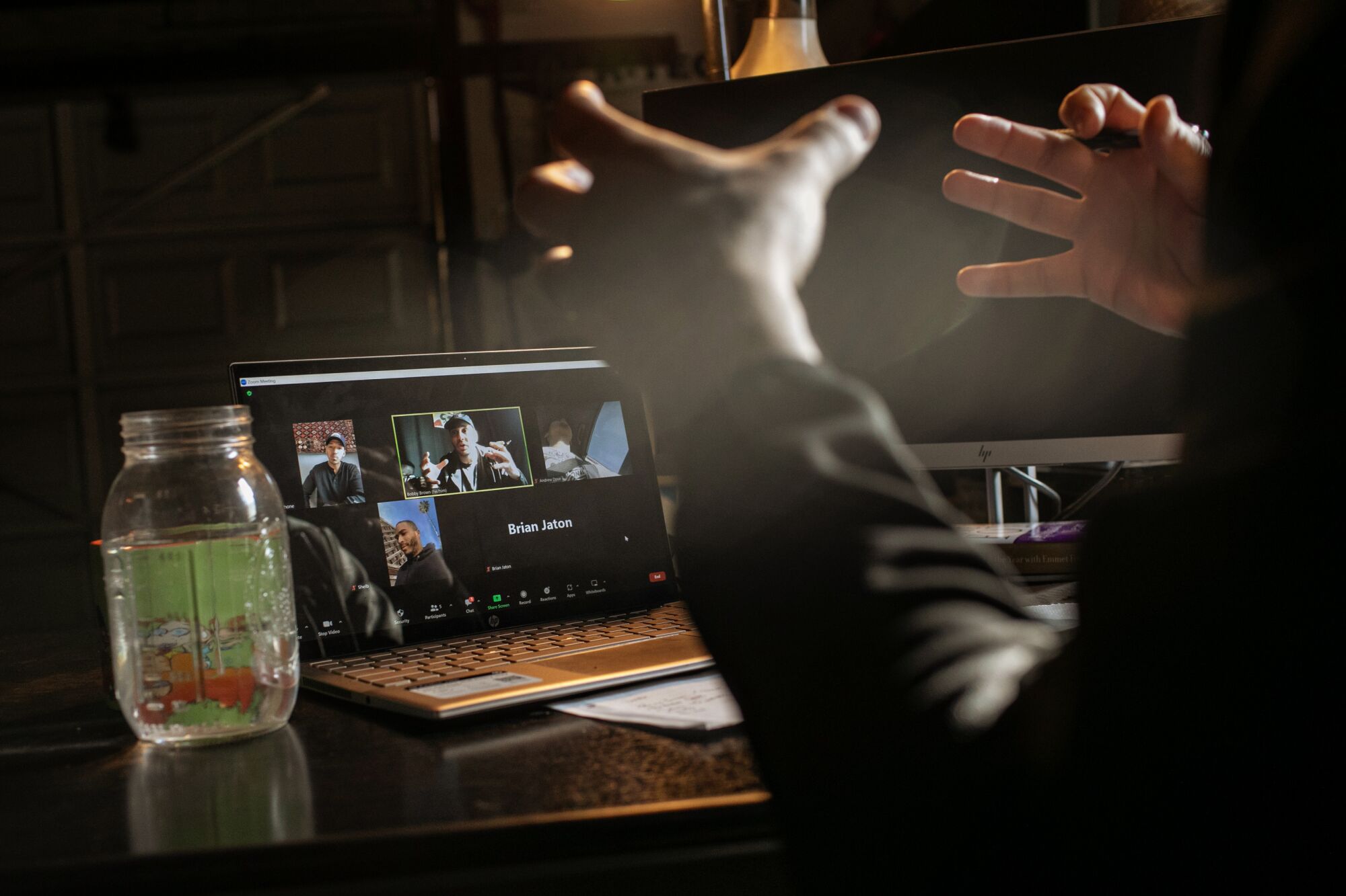 Bobby Brown gestures with his hands during a video meeting with other fathers, whose images appear on his laptop.