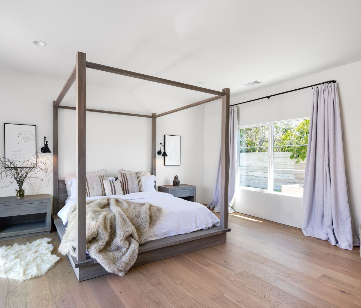 The master bedroom gets a lot of natural light from the large window to the side yard. 