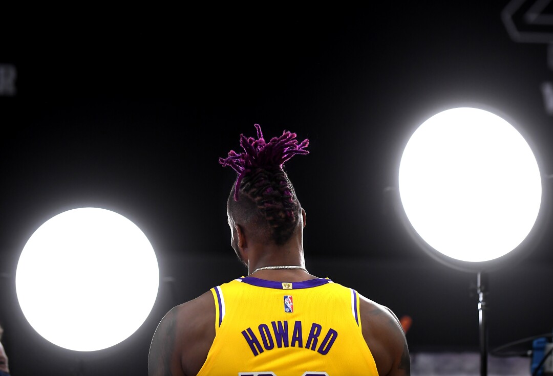 Lakers Dwight Howard seen from the back in his uniform and purple locks while he faces two lights