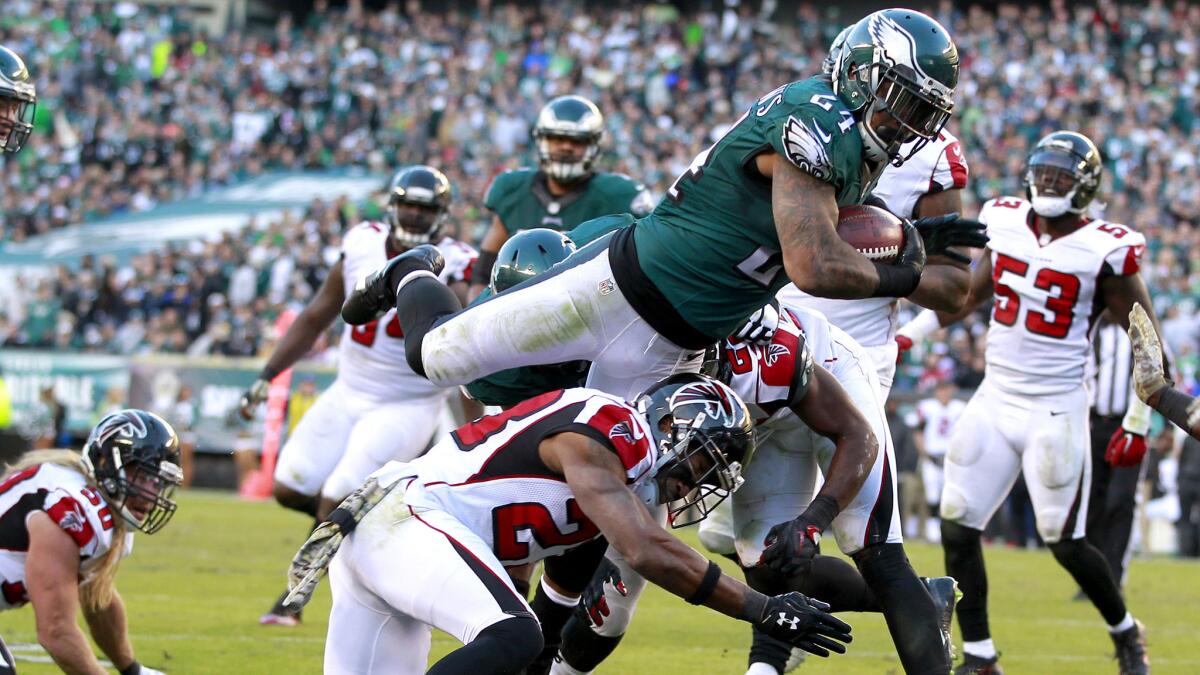 Eagles running back Ryan Mathews leaps over Falcons defensive back Robert Alford to score a touchdown in the fourth quarter Sunday.