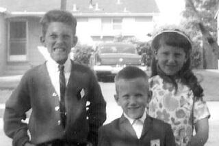 A black and white photo of three children in front of a suburban home.