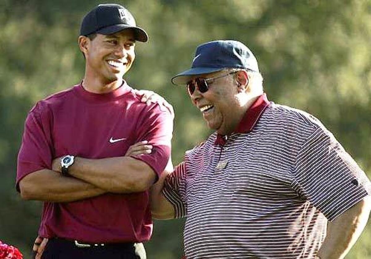 Tiger Woods smiles as he stands with his father, Earl, at the Target World Challenge on Dec. 12, 2004, in Thousand Oaks.