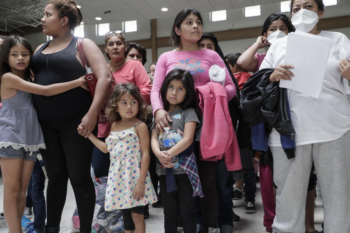 Immigrant families wait to be processed at Central Station in McAllen, Texas, after being released from federal custody on July 26.
