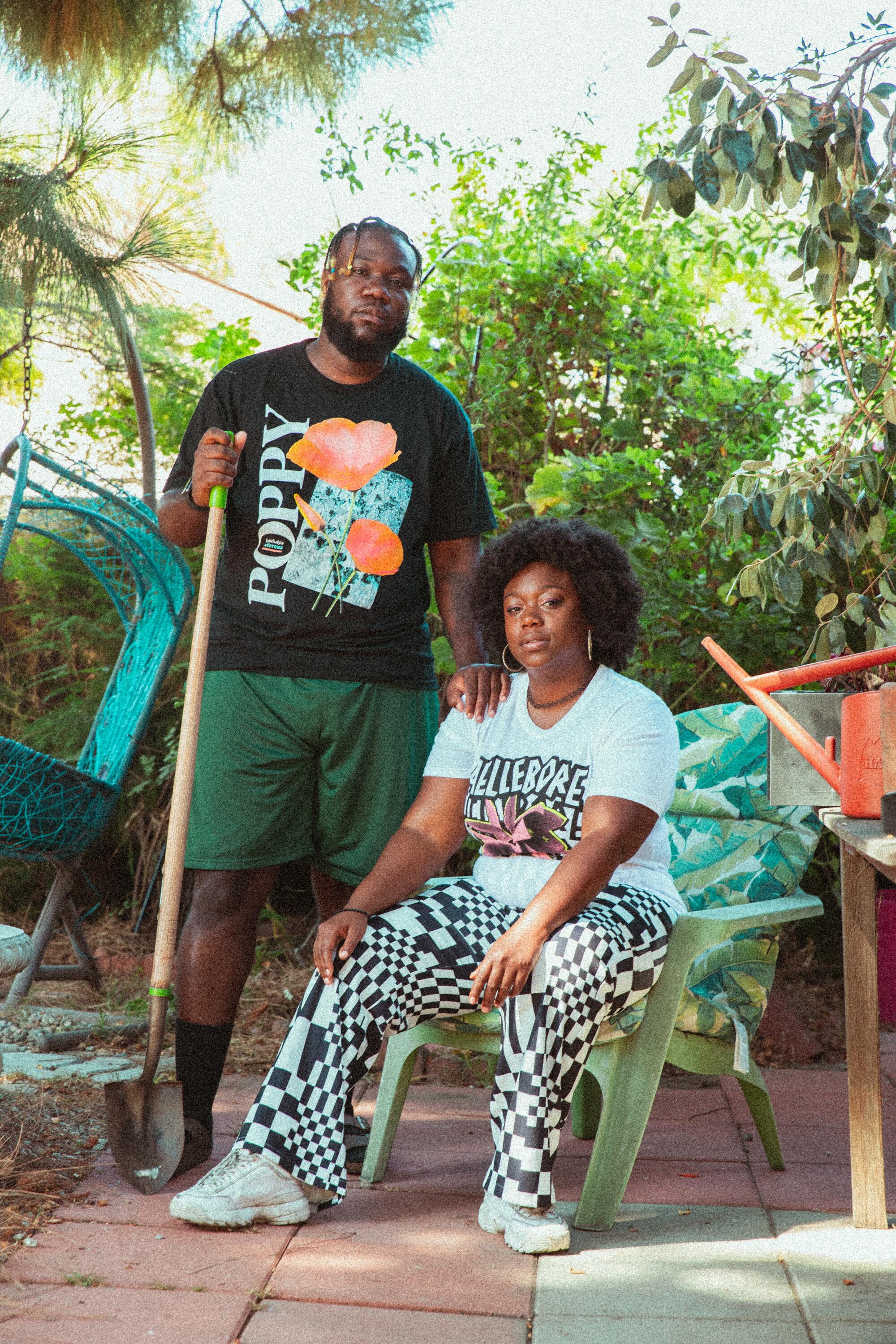 Two people model tees from Heavy Petal that feature poppies and other plants in bright graphics
