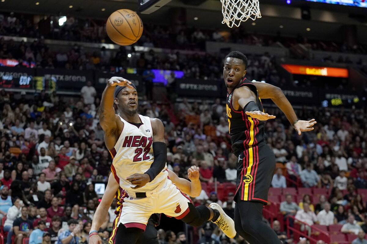 Miami Heat forward Jimmy Butler (22) passes the bal as Atlanta Hawks forward Onyeka Okongwu defends during the second half of an NBA basketball game Friday, April 8, 2022, in Miami. The Heat won 113-109. (AP Photo/Lynne Sladky)
