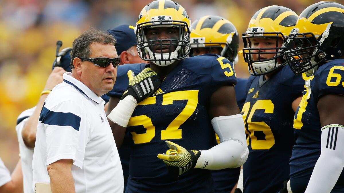 Michigan Coach Brady Hoke talks with his players during a loss to Utah on Sept. 20. The Wolverines' 2-3 record is only one of the problems threatening Hoke's tenure in Ann Arbor.