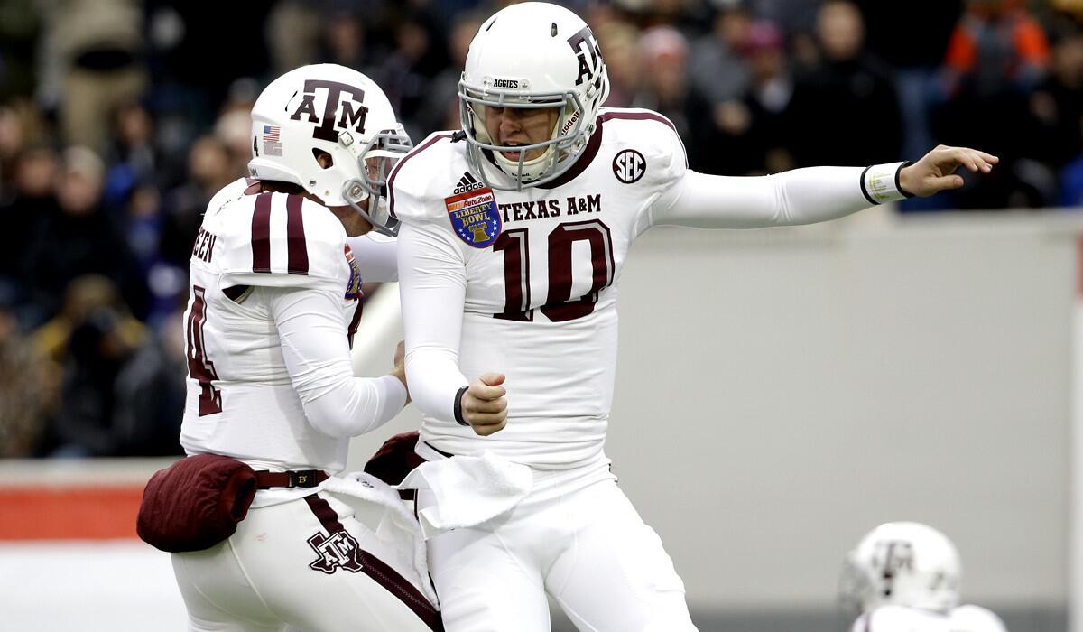 Texas A&M quarterback Kyle Allen (10) celebrates with Conner McQueen (14) after scoring against West Virginia in the first half of the Liberty Bowl on Monday.