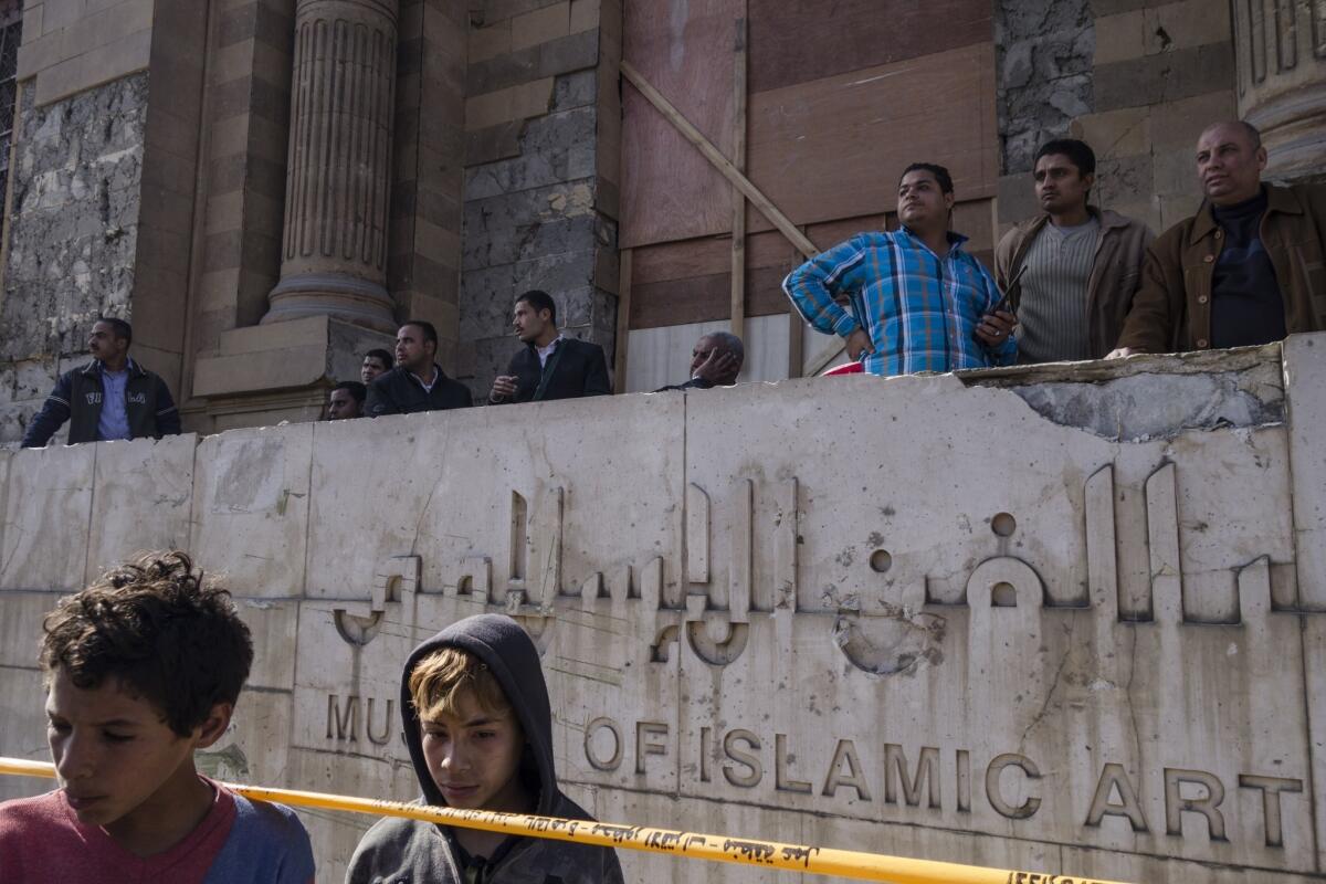 Egyptians stand outside the Museum of Islamic Art in Cairo, which was damaged by a bomb attack at a nearby police building.