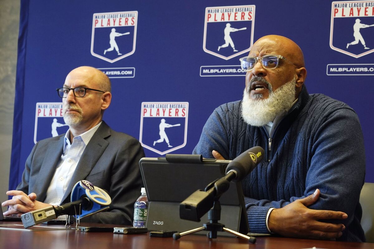 Major League Baseball Players Association Executive Director Tony Clark, right, answers a question at a press conference in their offices in New York, Friday, March 11, 2022. Major League Baseball’s players and owners ended their most bitter money fight in a quarter-century Thursday when the players’ association accepted management’s offer to salvage a 162-game season that will start April 7. At left is Bruce Meyer, Senior Director, Collective Bargaining & Legal. (AP Photo/Richard Drew)