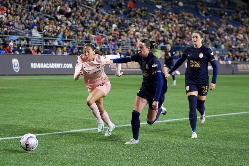 Angel City FC forward Christen Press vies for the ball against Seattle Reign defender Phoebe McClernon.