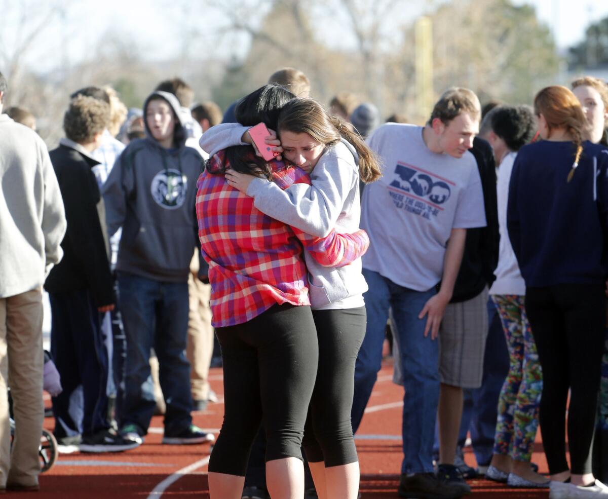 Students comfort each other at Arapahoe High School in Centennial, Colo., after a student opened fire.