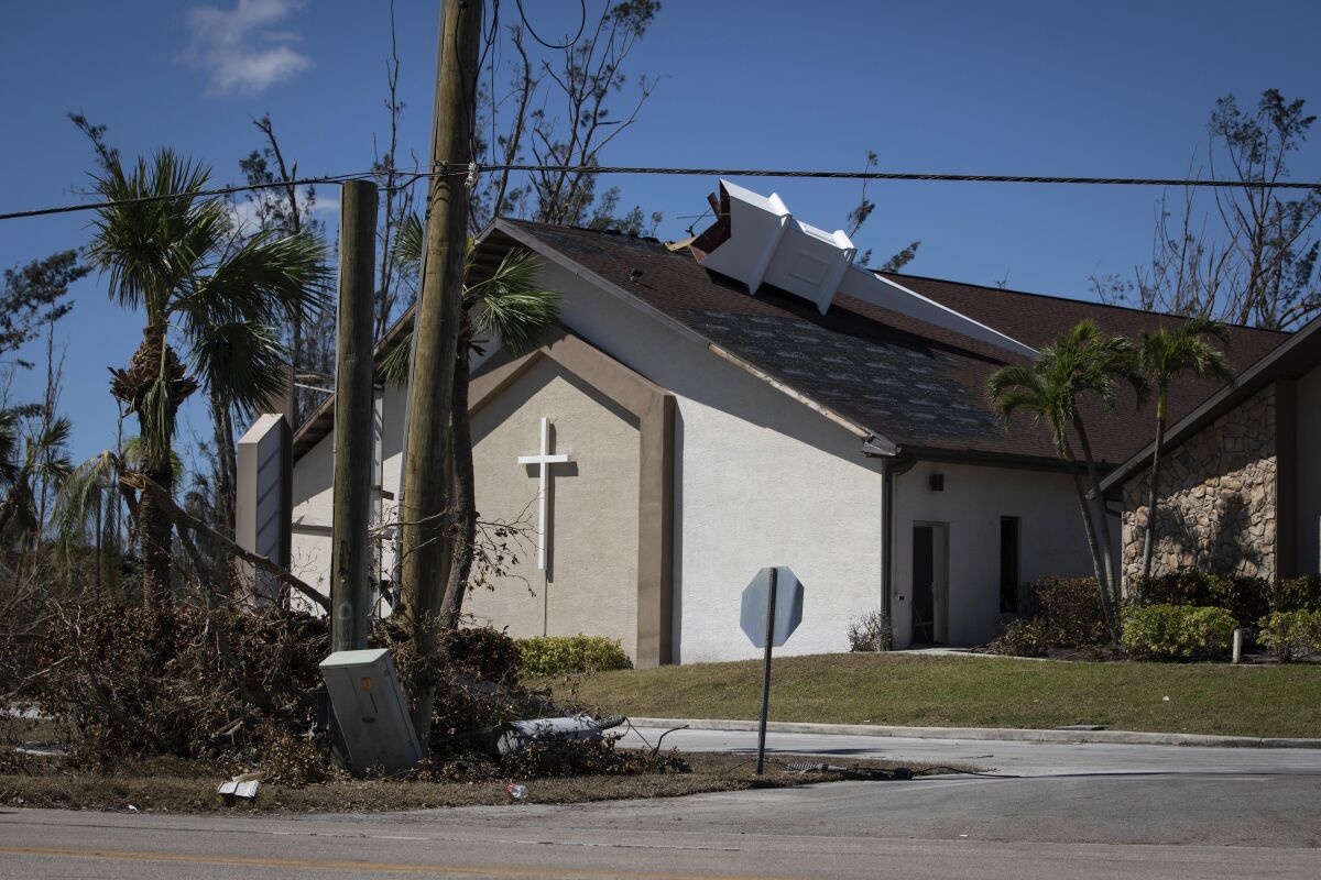 The steeple lays on its side atop Southwest Baptist Church in Fort Myers, Fla., on Sunday, Oct. 2, 2022. The church sustained heavy wind and flooding damage during Hurricane Ian as parishioners took refuge in the sanctuary. (AP Photo/Robert Bumsted)