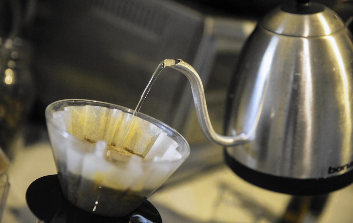 Times reporter Jason Song pours hot water over freshly ground coffee beans at his South Pasadena home. He's been roasting single-origin coffee in his backyard for years.