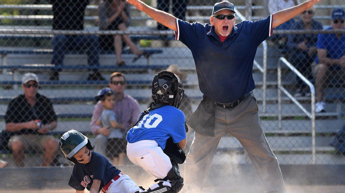 Umpire Pete Constantino calls a play at home plate during a Southwest Pasadena little league game. Constantino has been an umpire for 40 years.