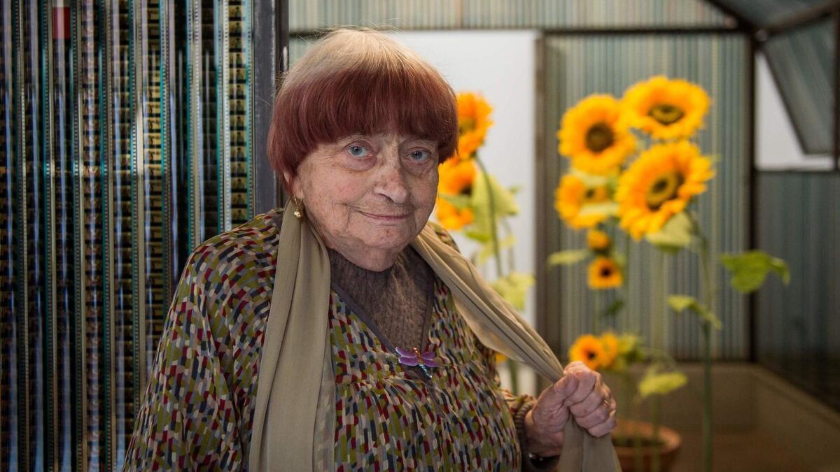 Agnès Varda poses next to her art installation "La Serre du Bonheur."