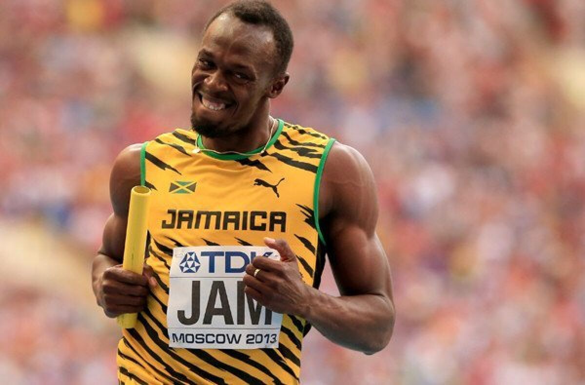 Usain Bolt flashes a grin as he crosses the finish line to give Jamaica the win in the 400-meter relay Sunday at the world track championships.