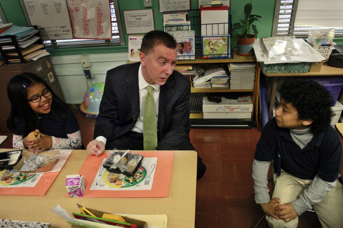 L.A. Unified Supt. John Deasy talks with students at Figueroa Street Elementary School, with breakfast in front of them.