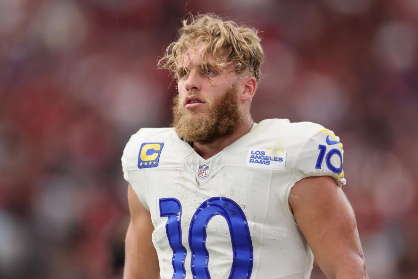 Rams receiver Cooper Kupp stands on the sideline with his helmet off.