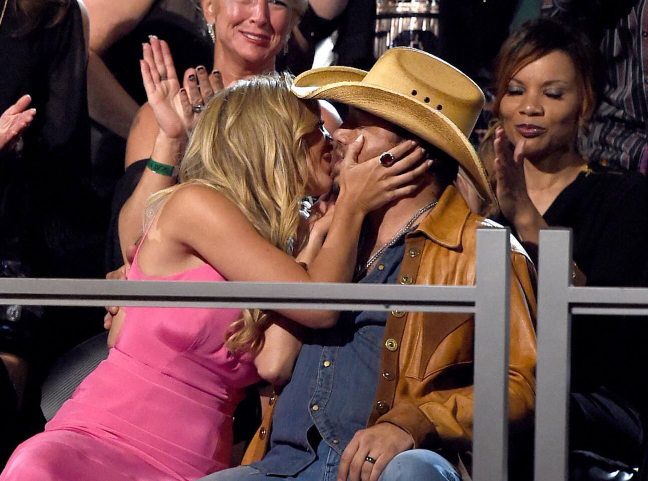 Cheerleader Brittany Kerr kisses singer Jason Aldean after he wins the award for male vocalist of the year during the 50th Academy Of Country Music Awards.