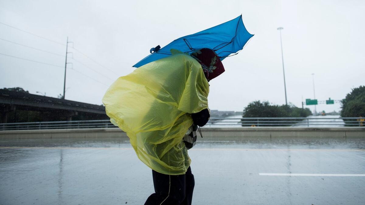 A woman walks through the rain in Houston, Texas on Aug. 28, 2017.