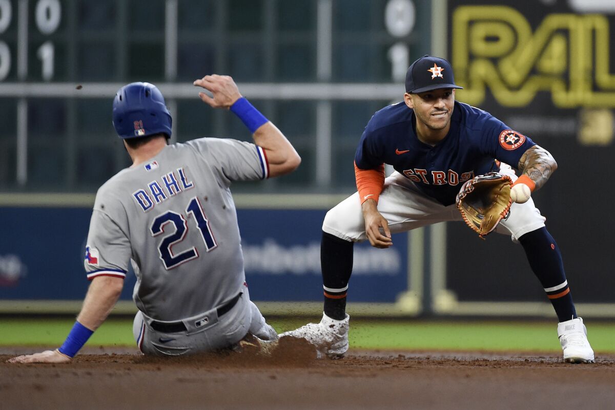 Houston Astros shortstop Carlos Correa, right, puts out Texas Rangers' David Dahl during a fielder's choice during the second inning of a baseball game, Sunday, July 25, 2021, in Houston. Brock Holt was safe at first. (AP Photo/Eric Christian Smith)