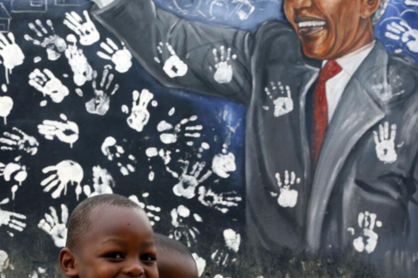 Two boys walk past a mural depicting former South African President Nelson Mandela at the Alexandra township in Johannesburg, South Africa. Mandela died at the age of 95 on Thursday.