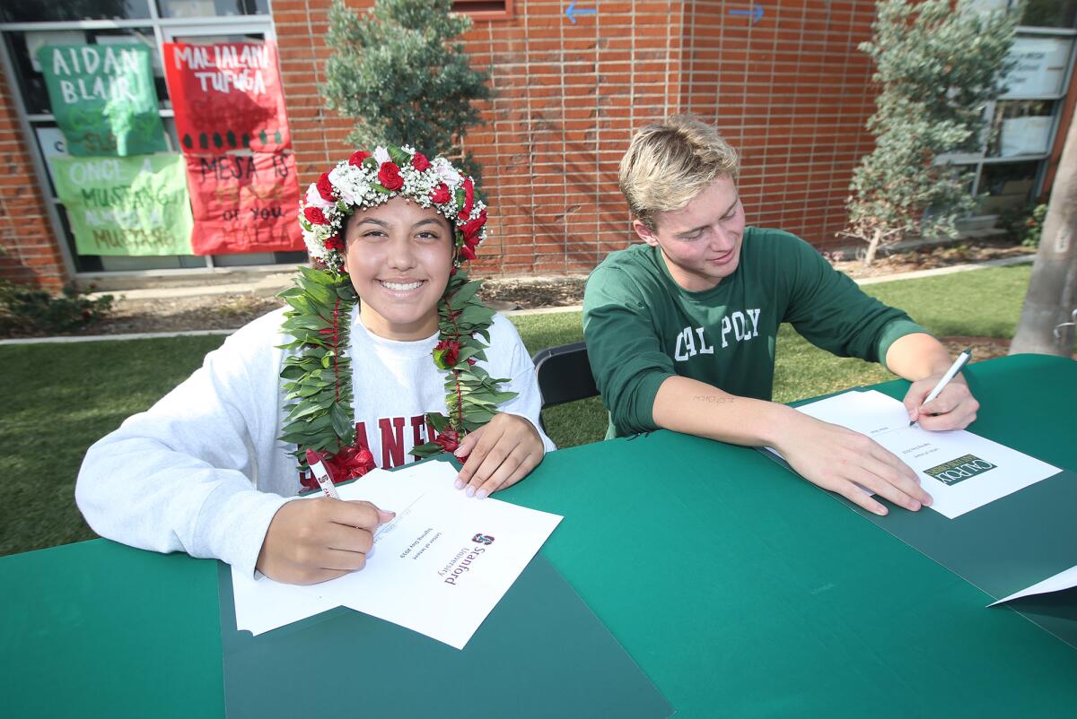 Costa Mesa athletes Malia Tufuga, left, and Aidan Blair sign their national letters of intent on Wednesday. Tufuga will play women's volleyball at Stanford and Blair will swim for the men's team at Cal Poly San Luis Obispo.
