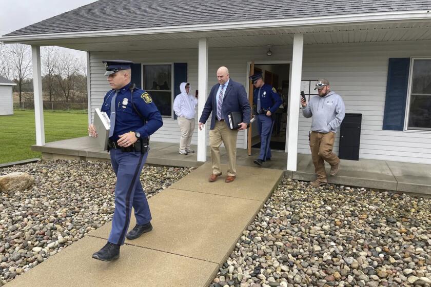 FILE - The Michigan State Police exit the Adams Township Hall after executing a search warrant, Oct. 29, 2021, in Hillsdale, Mich. Michigan Attorney General Dana Nessel announced charges Wednesday, May 8, 2024, against former Adams Township Clerk Stephanie Scott and her attorney, Stefanie Lambert, who is pro-Trump, for allegedly allowing unauthorized access to a computer and its voter data in a search for fraud related to the 2020 election. (Corey Murray/Hillsdale Daily News via AP, File)