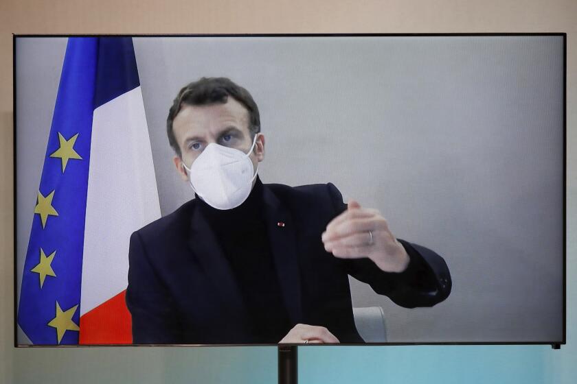 French President Emmanuel Macron is seen on a screen as he attends by video conference a round table for the National Humanitarian Conference (NHC), taken at the Foreign Ministry in Paris,Thursday, Dec. 17, 2020. French President Emmanuel Macron tested positive for COVID-19 Thursday following a week in which he met with numerous European leaders. (Charles Platiau/Pool via AP)