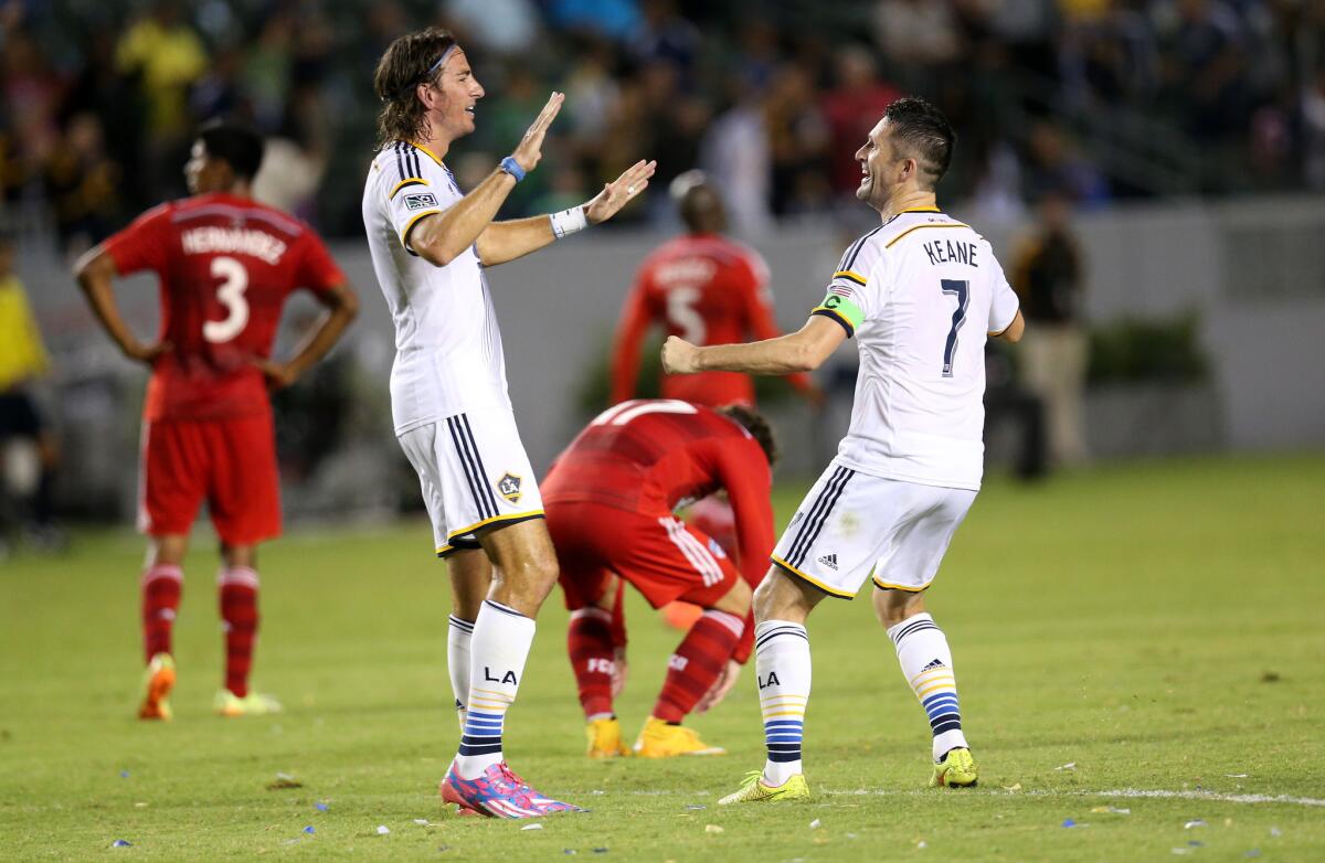 Alan Gordon, left, and Robbie Keane celebrate Gordon's goal Saturday against Dallas FC. The Galaxy clinched a playoff spot with the 1-0 victory.