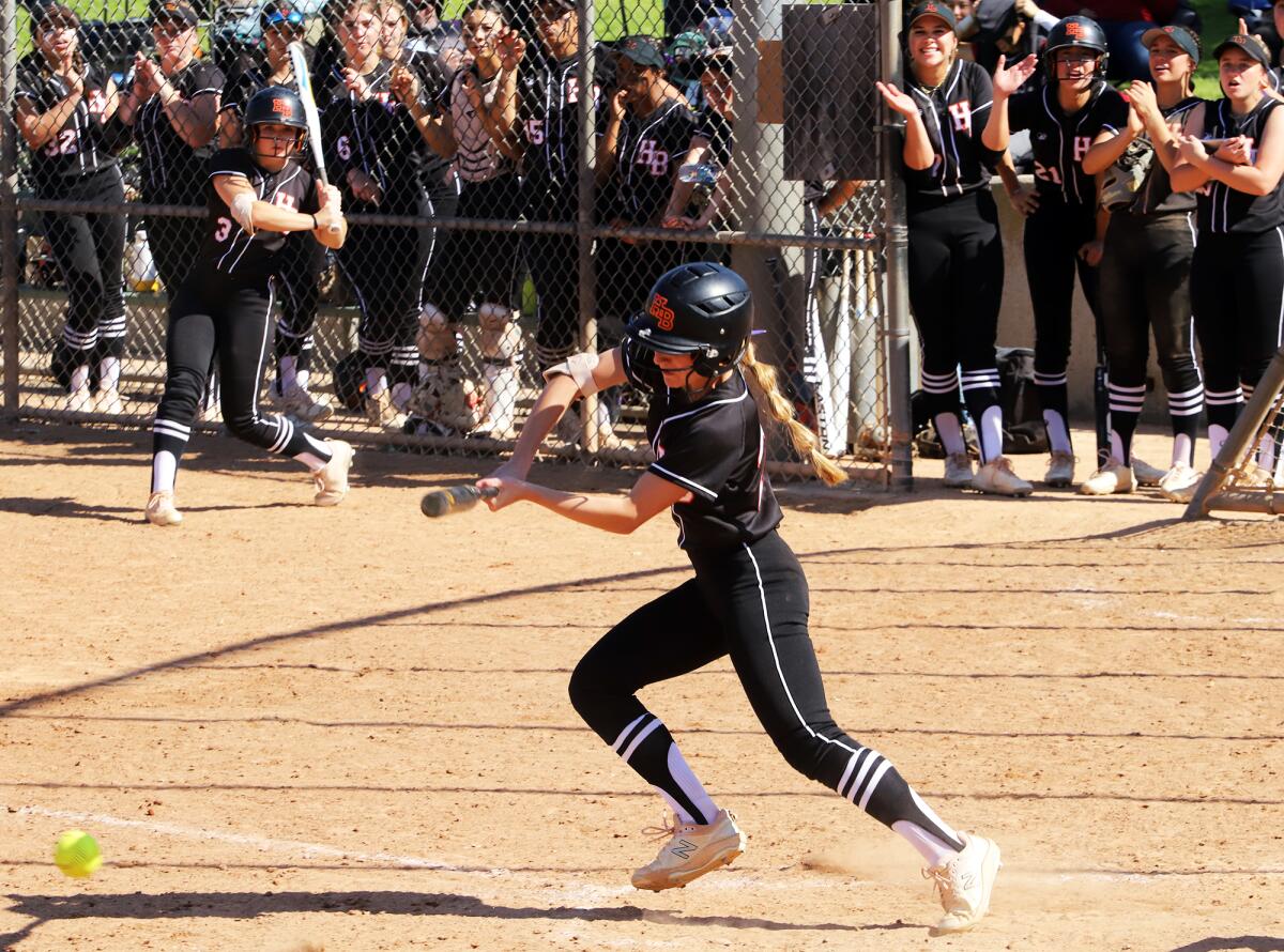 Huntington Beach's Macy Fuller (27) lays down a bunt against Los Alamitos in the Michelle Carew Classic on Saturday.
