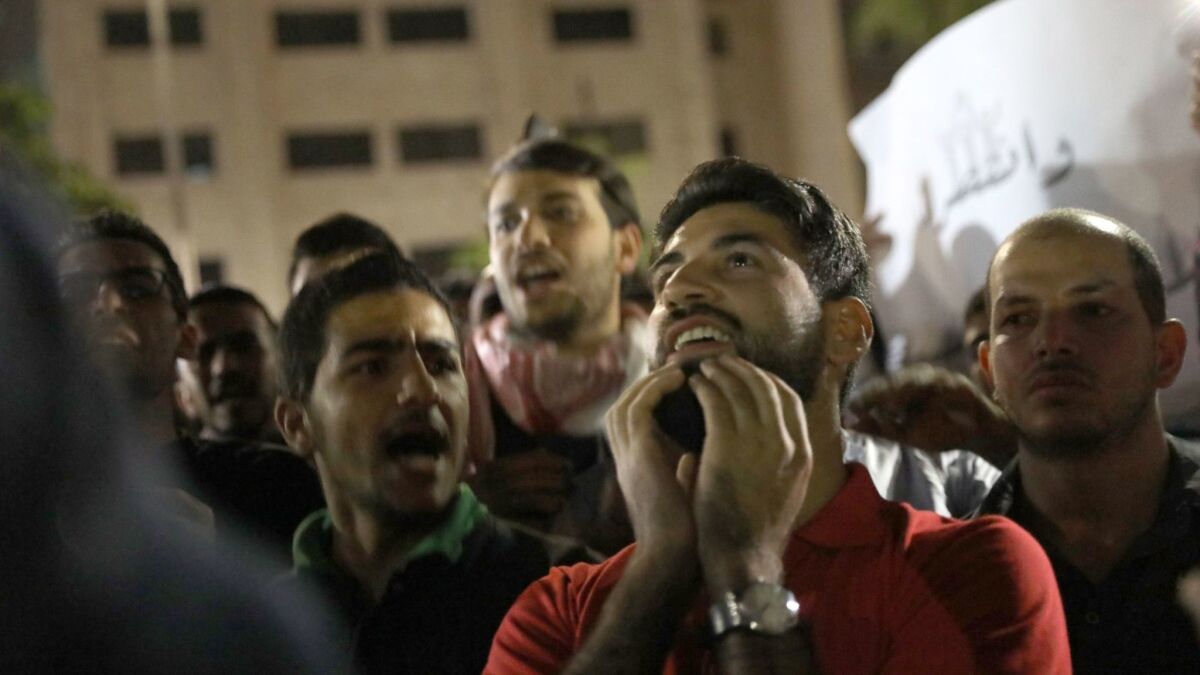 Protesters celebrate as Jordan's new prime minister, Omar Razzaz, announces withdrawal of a disputed tax reform in Amman, Jordan, on June 8, 2018.