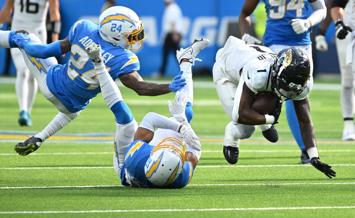 The Jaguars' Travis Etienne picks up a first down in front of Chargers Nasir Adderley (24) and Bryce Callahan in September.