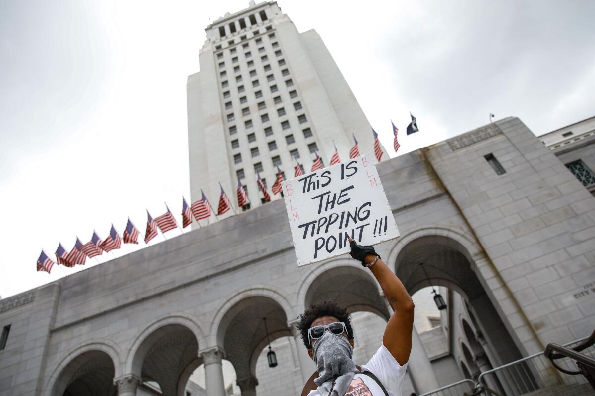 A protester with a sign that reads, "This Is The Tipping Point!!!" outside Los Angeles City Hall in June 2020.