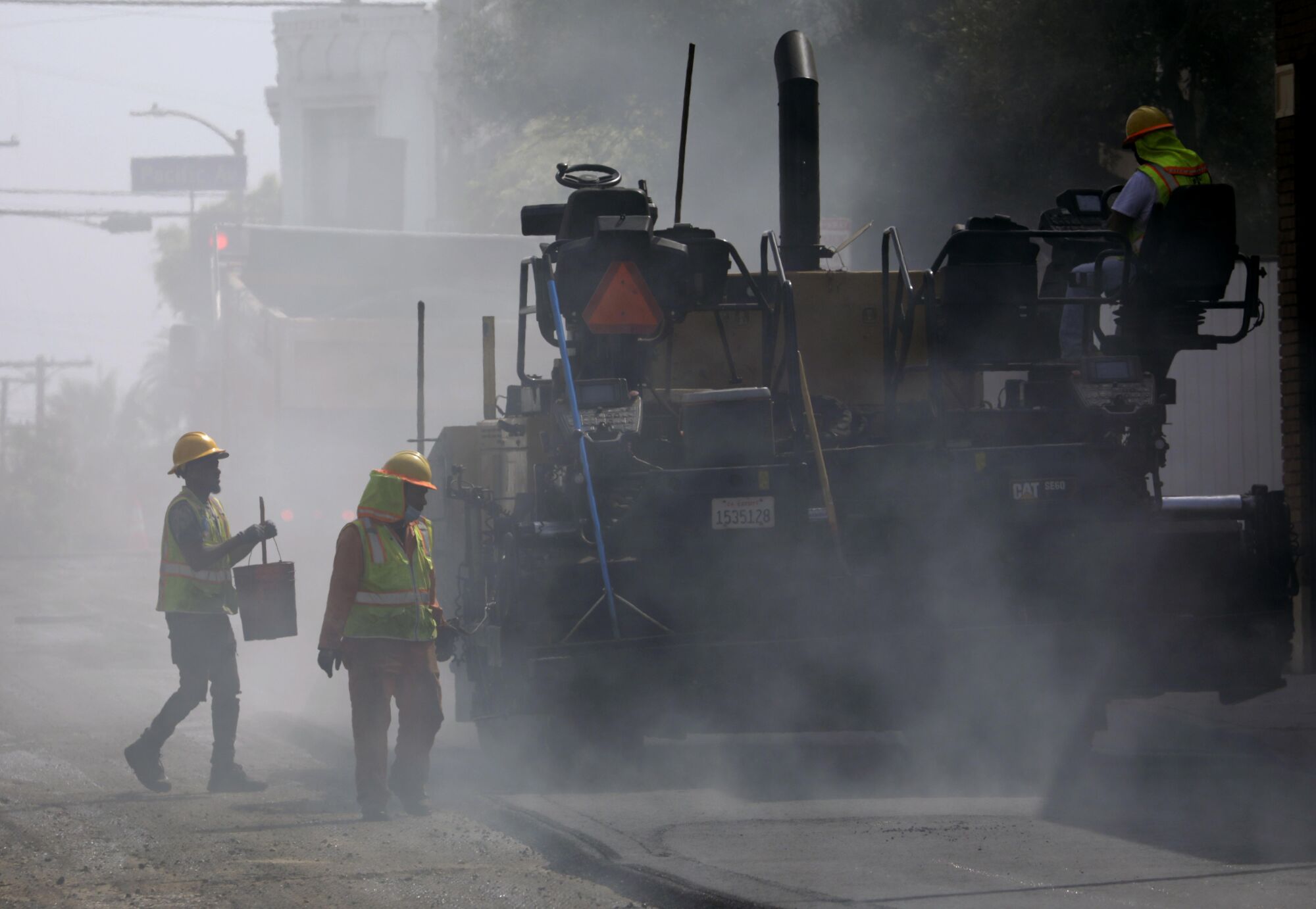 Construction workers lay asphalt