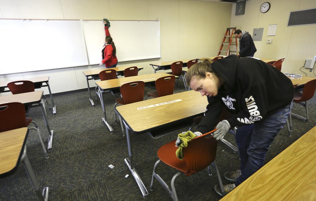 L.A. Unified maintenance workers, from left, Patricia Nolasco, Alexis Delahoussaye and Jorge Velasco clean one of 35 prebuilt bungalows set up at Northridge Middle School for students relocated from Porter Ranch Community School.