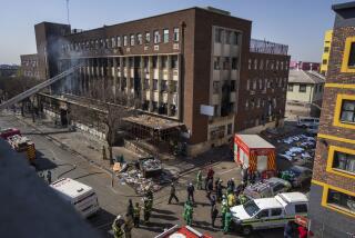 Medics and emergency works at the scene of a deadly blaze in downtown Johannesburg Thursday, Aug. 31, 2023. Dozens died when a fire ripped through a multi-story building in Johannesburg, South Africa's biggest city, emergency services said Thursday. (AP Photo/Jerome Delay)