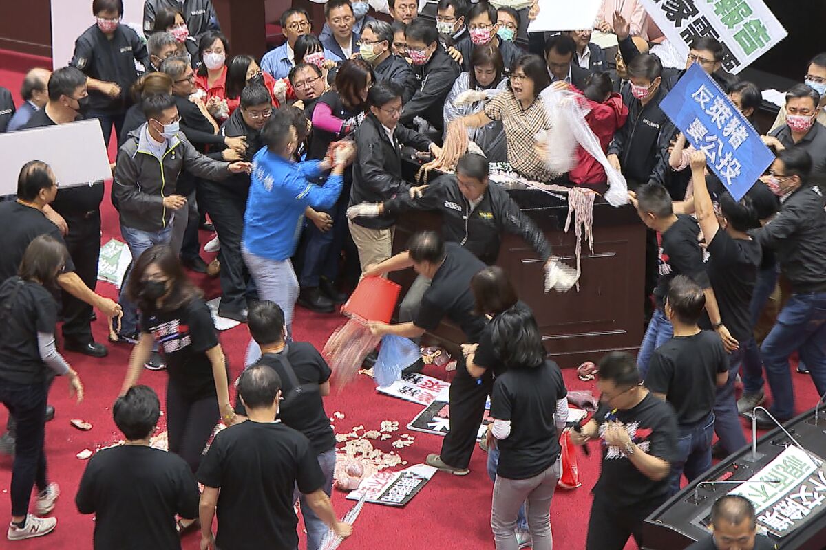 In this image made from video, lawmakers fight during a parliament session in Taipei, Taiwan.