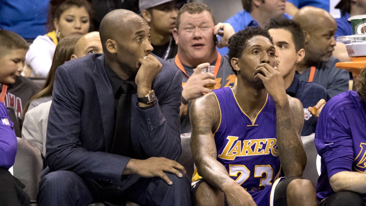 Kobe Bryant watches the Lakers' game Saturday against the Thunder on the bench next to teammate Lou Williams.