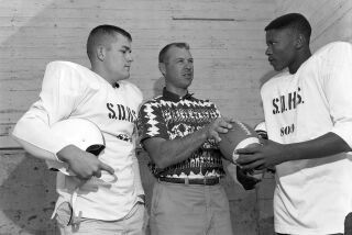September 4, 1958 -- San Diego High football coach Duane Maley (middle) talks to his his players Roy Pharis (left) and Willie McCloud. Photo: Charles Aquaviva/U-T San Diego/San Diego History Center