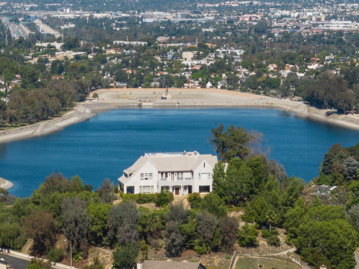 A home is shown beside a body of water.