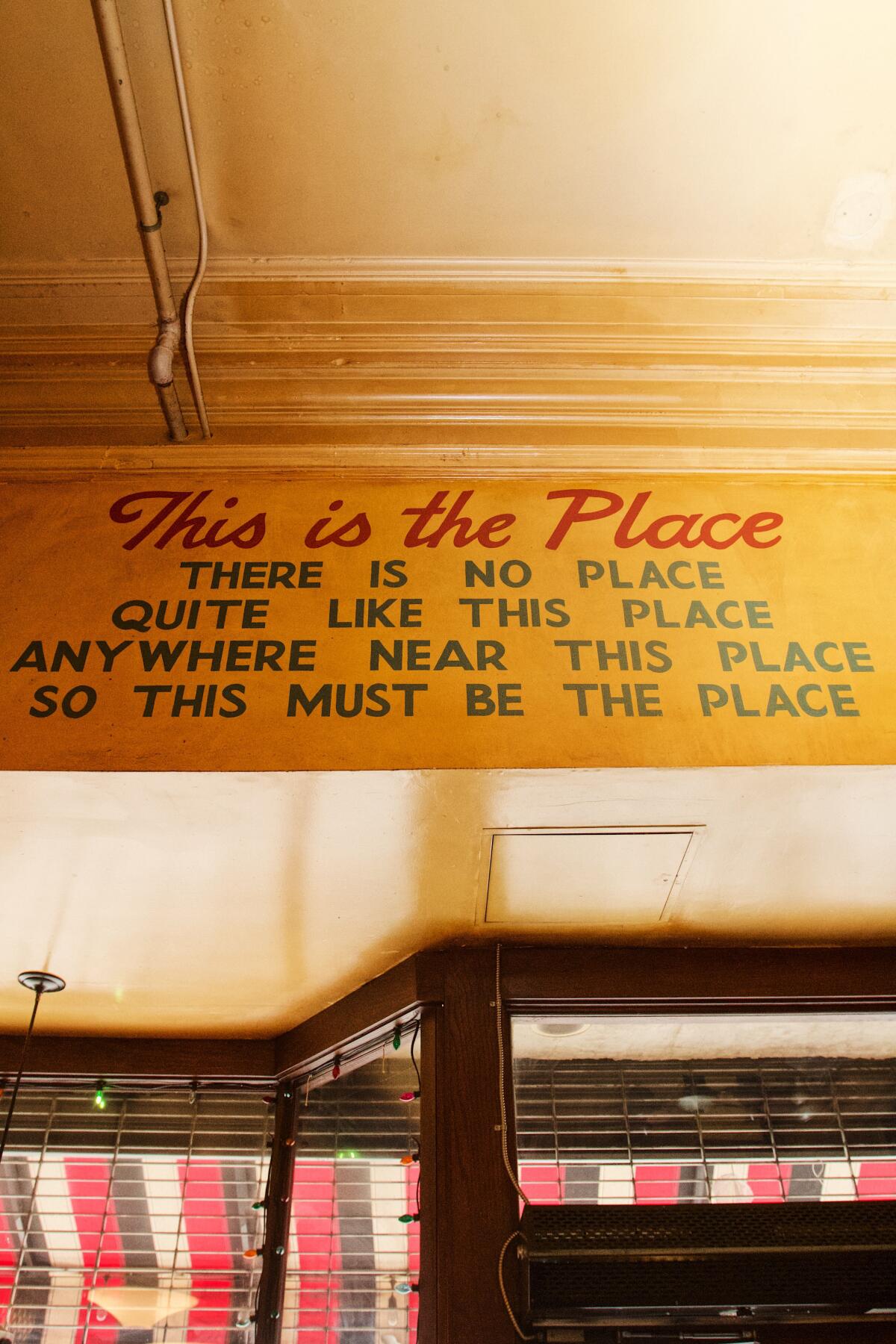 A sign that says “This is the place, there is no place / quite like this place anywhere near this place" above the front door