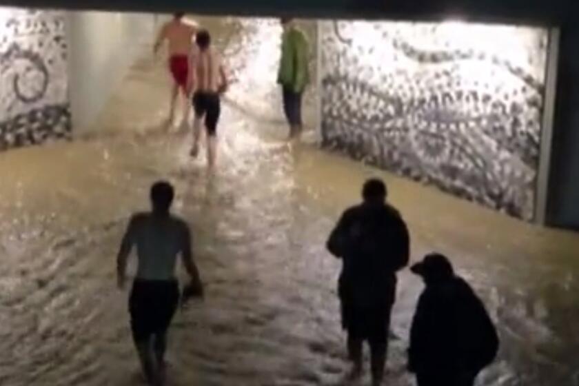 In this still frame made from ABC 7NEWS video on Thursday, Sept. 12, 2013, people walk through floodwaters from a creek in Boulder, Colo. Flash flooding in Colorado has left two people dead and the widespread high waters are keeping search and rescue teams from reaching stranded residents and motorists in Boulder and nearby mountain communities as heavy rains hammered northern Colorado.