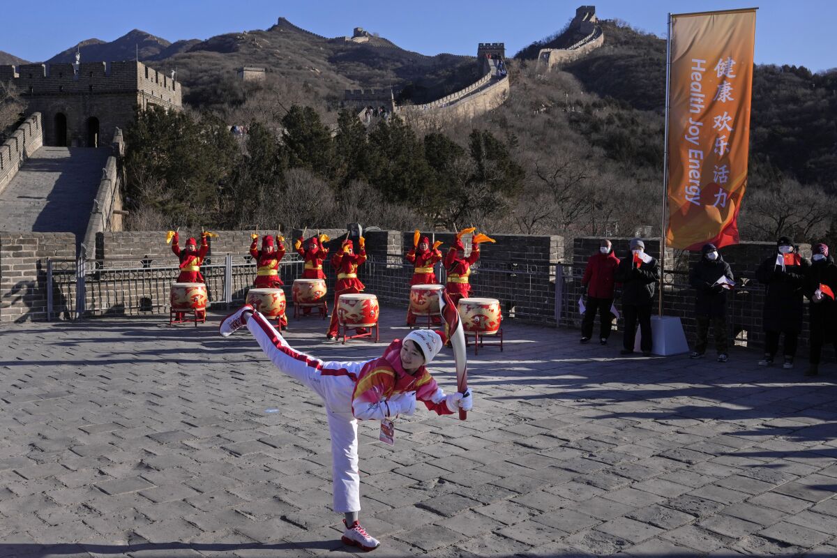 Wu Jingyu, China's Taekwondo Olympic Champion, poses with a kick before taking part in the torch relay for the 2022 Winter Olympics at the Badaling Great Wall on the outskirts of Beijing, China, Thursday, Feb. 3, 2022. (AP Photo/Ng Han Guan)