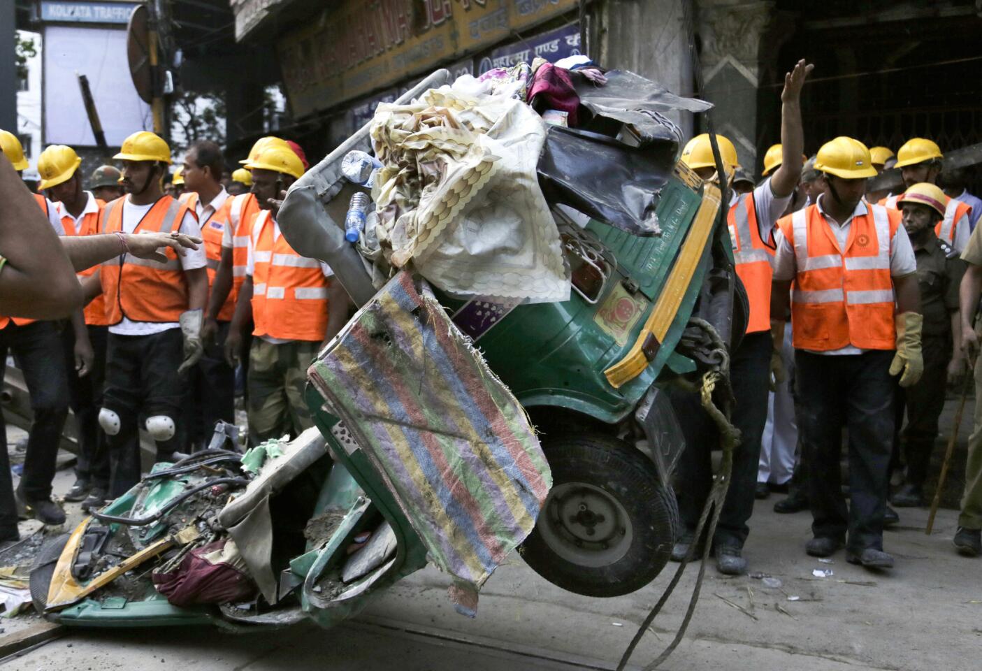 A damaged three-wheeled vehicle is taken out from the rubble of a collapsed overpass in Kolkata, India, on Arpil 1.
