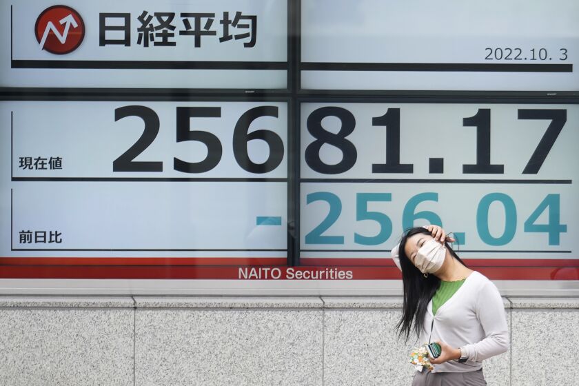 A person stands near an electronic stock board showing Japan's Nikkei 225 index at a securities firm Monday, Oct. 3, 2022, in Tokyo. Asian shares were mostly lower on Monday after Wall Street closed out a miserable September with a loss of 9.3%, the worst monthly decline since March 2020. (AP Photo/Eugene Hoshiko)