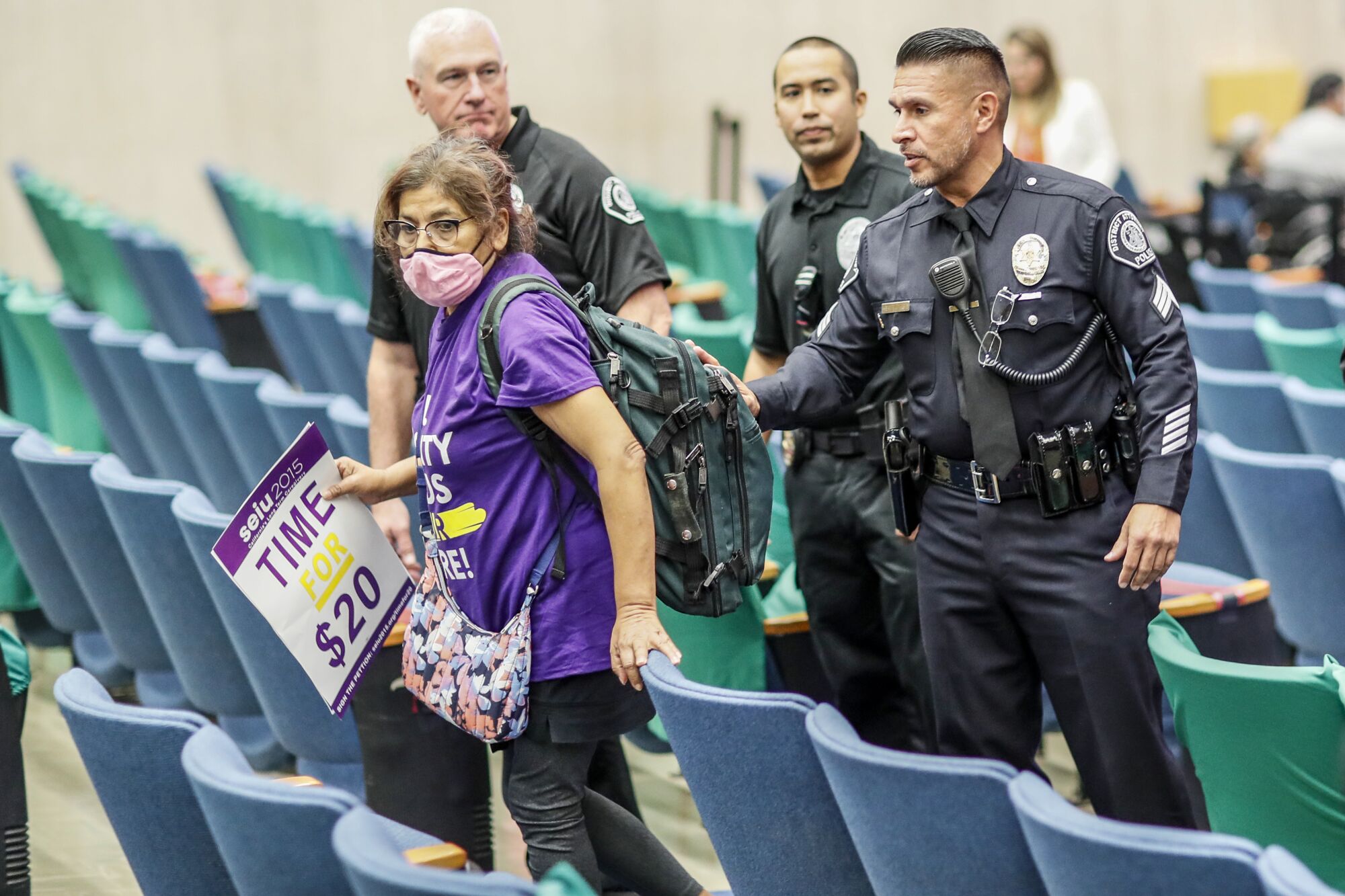 Police direct a spectator out of  the Kenneth Hahn Hall of Administration after a protest 