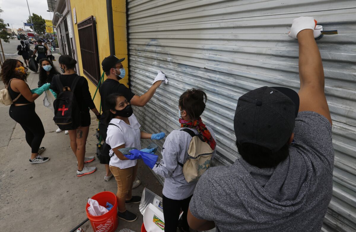 Volunteers scrub grafitti along a stretch of Western Avenue.
